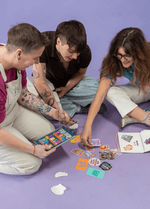 Three people look through a pile of stickers to add to their Sticker Libraries.