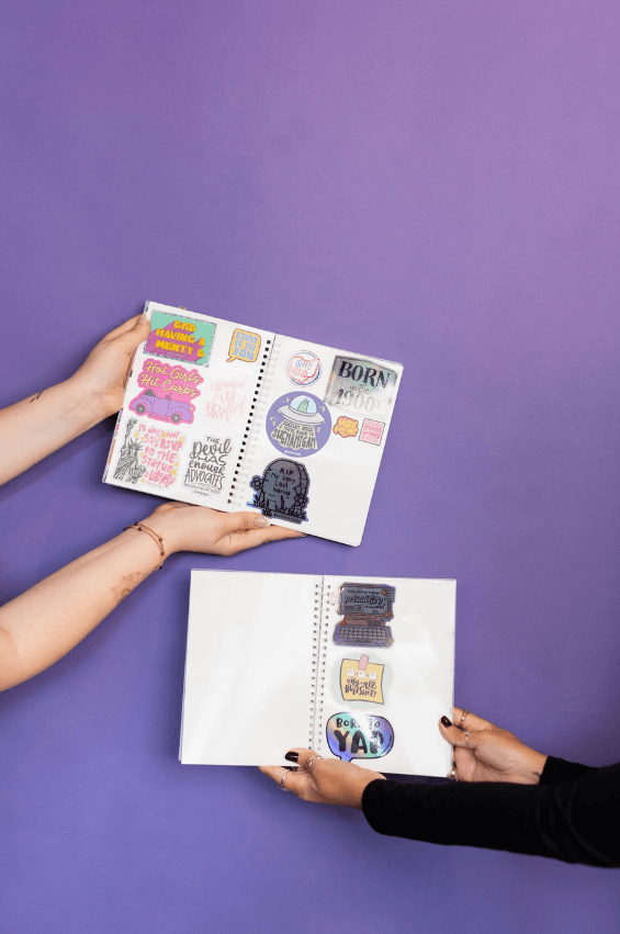 Two different sets of arms reach across from different directions, revealing two different sets of sticker collections in the Sticker Party Album.