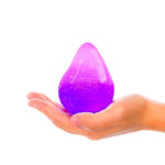 A hand holds the purple Nee Doh Dream Drop.