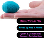 A hand holds up a blue football from the Teenie Nee Doh Hot Shots.