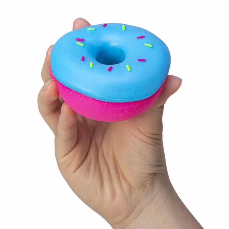 A hand holds the blue NeeDoh Dohnut.