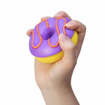 A hand holds up the purple NeeDoh Dohnut.