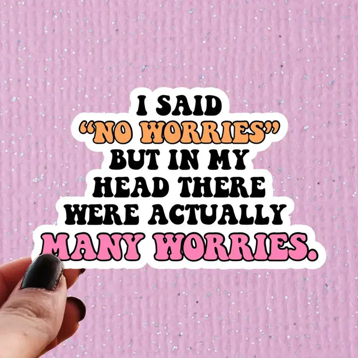A hand holds up a sticker that reads: I Said "No Worries" But In My Head There Were Actually Many Worries.
