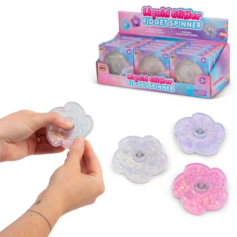 A hand holds up a Liquid Glitter Fidget Spinner in front of the display case.
