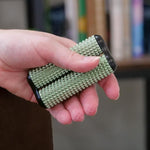 A hand rolls the Sage ONO Aluminum Acupressure Roller. There are acupressure dimples on the tips of the fingers.