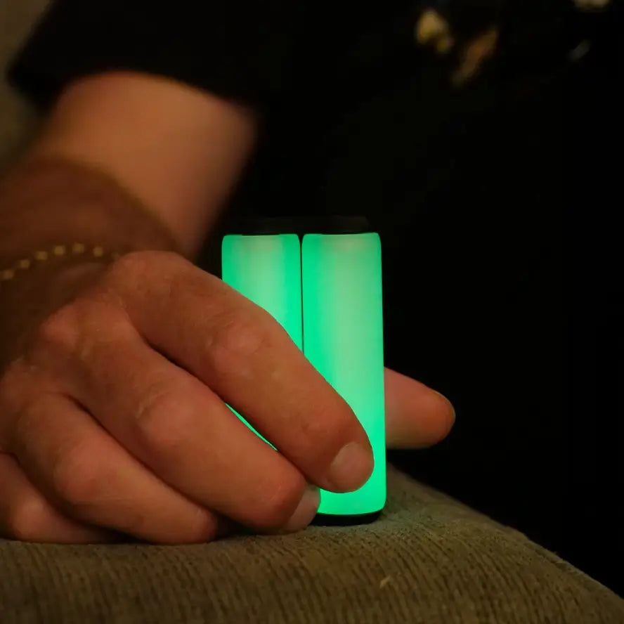 A hand holds the Ono Roller Glow-in-the-Dark junior size while it is glowing.