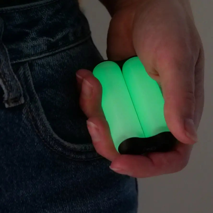 A hand holds the Ono Roller Glow-in-the-Dark junior size while it is glowing.