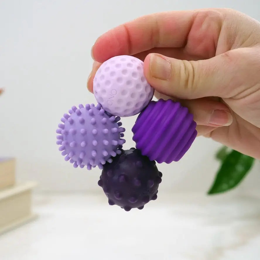 A hand holds the four lavender ONO Roller Signets connected in a circle.