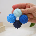 A hand holds the four sapphire ONO Roller Signets while connected in a circle.