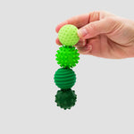 A hand holds four Emerald ONO Signets.