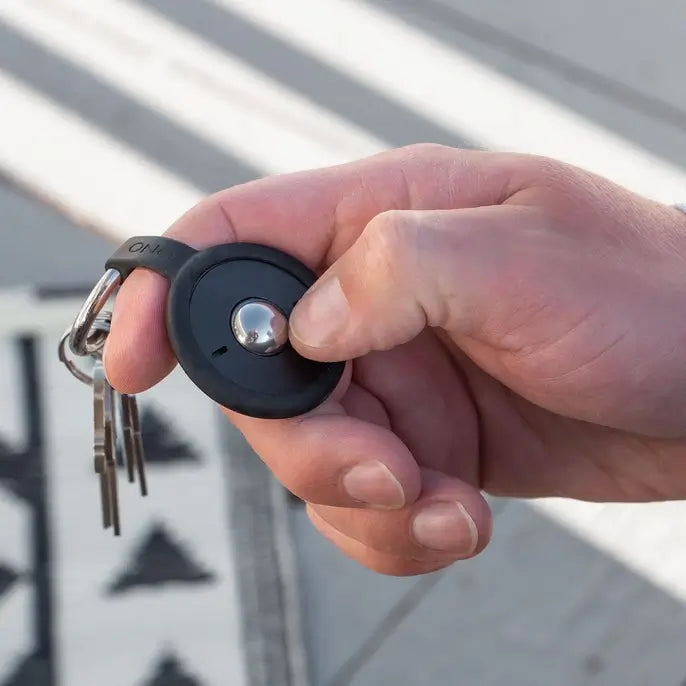 A hand holds the ONO Scroller Keychain.