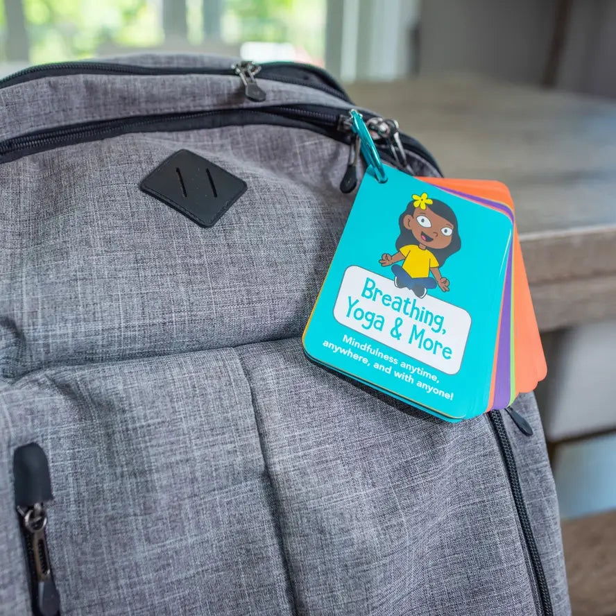 A carabiner holds the Mindful Minute Conversation Cards to a backpack.