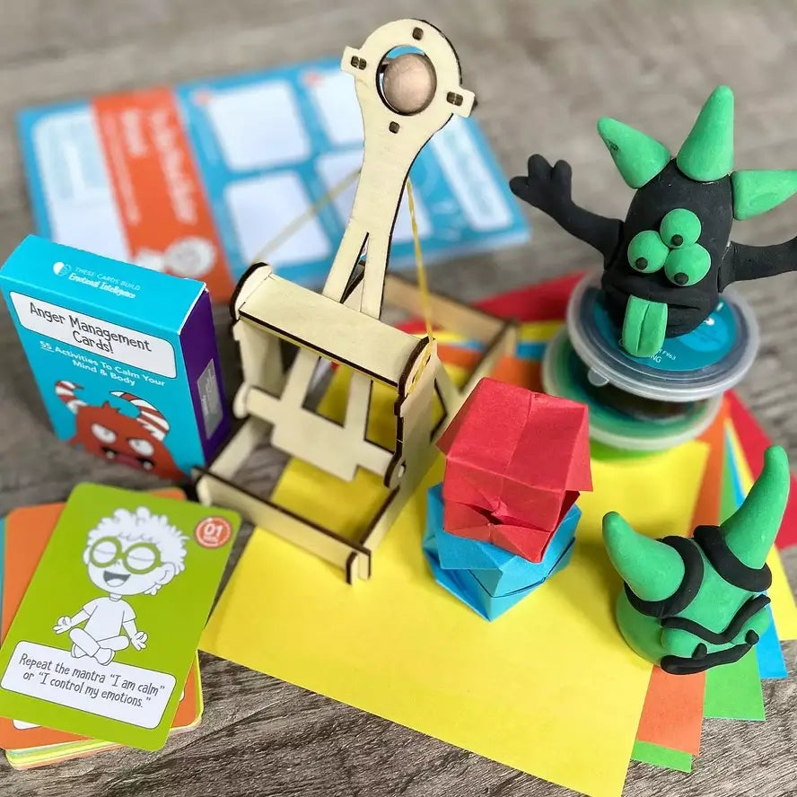 The anger managment cards, wooden catapult, and clay that come in the Anger Management in a Box Tool Kit.