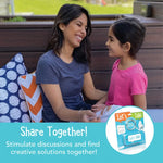 An adult and a child smile at each other while holding the Let's Talk Portable Conversation Cards.