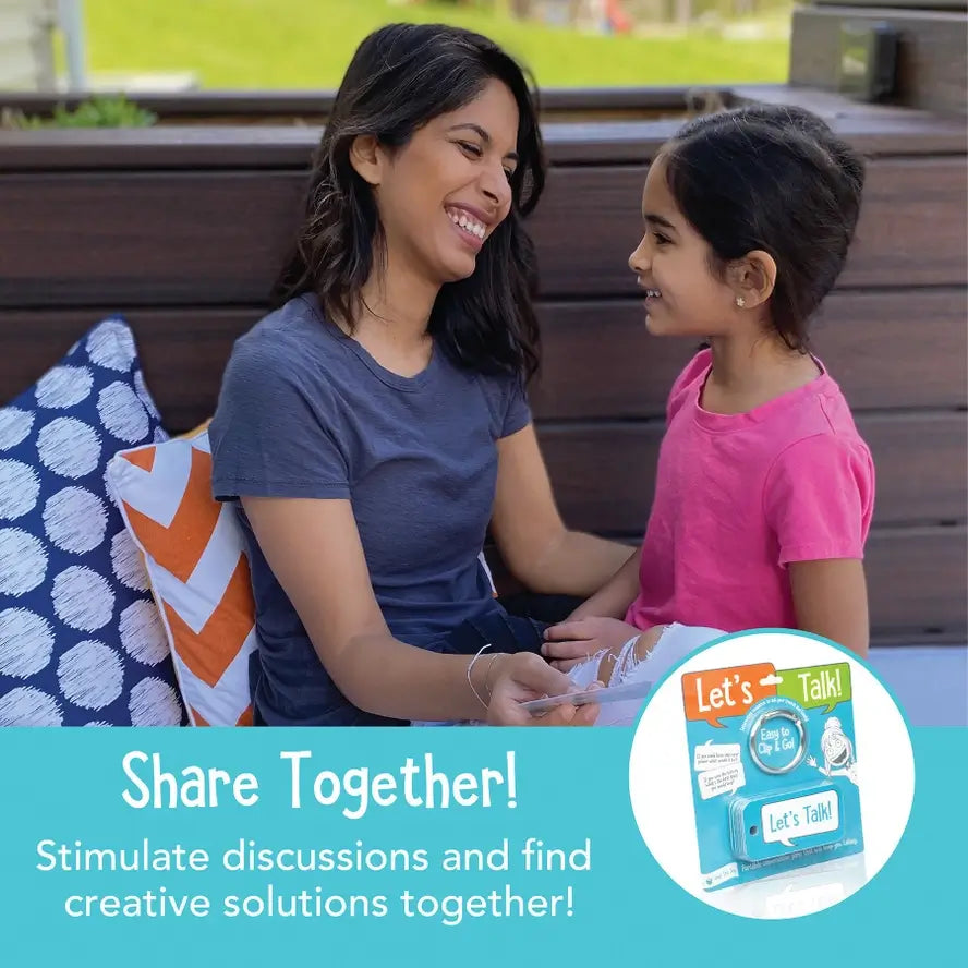 An adult and a child smile at each other while holding the Let's Talk Portable Conversation Cards.