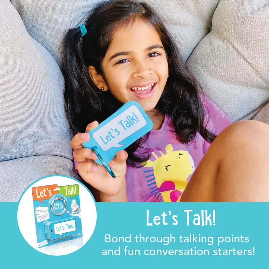 A child smiles and holds up the Let's Talk Portable Conversation Cards.