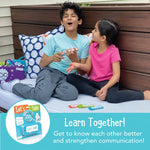 Two children laugh while holding the Let's Talk Portable Conversation Cards.