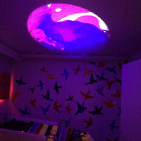 The roof of a room displays a Liquid Wheel projection from the Aura Sensory Light Projector.