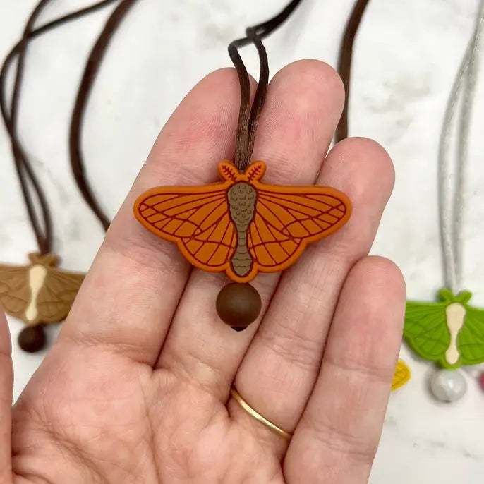 The orange chewy Moth Fidget Necklace.
