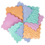 The 8 pastel mats that come in the Ortodon Puzzle Mat set arranged in a neat pinwheel.