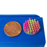 A penny sits on a ledge next to the Silicone Zen Mini Dot.