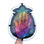 A hand pushes into the Pineapple Rainbow Pin Art.