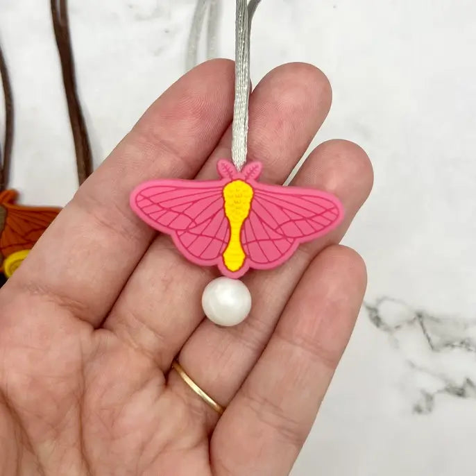 The pink chewy Moth Fidget Necklace.