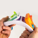 Two adult hands bend the flexible ABS travel board to demonstrate the interchangeable nature of the toy.