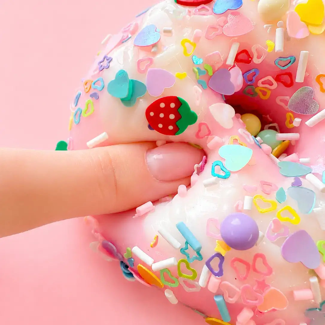 A finger gently pokes the Sugar Rush Donut Taba Squishy.