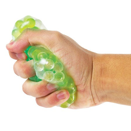 A hand with light skin tone squishes the Light Up Frog Stress Ball.