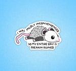 A sticker with a cartoon opossum on its belly that has the text: I Was Mildly Inconvenienced So My Entire Day is Freakin Ruined.