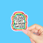 A sticker with a rainbow border and white squiggles that reads: The Older I Get, the Heller the No.
