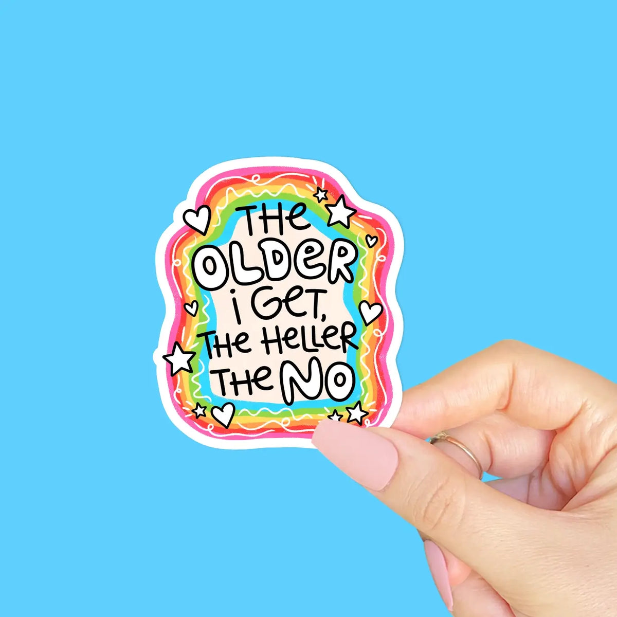 A sticker with a rainbow border and white squiggles that reads: The Older I Get, the Heller the No.