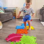A child crosses the spread of Rainbow Sensory Playmats.
