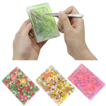 A hand uses tweezers to pull out items from a Rectangular Pick Pad.