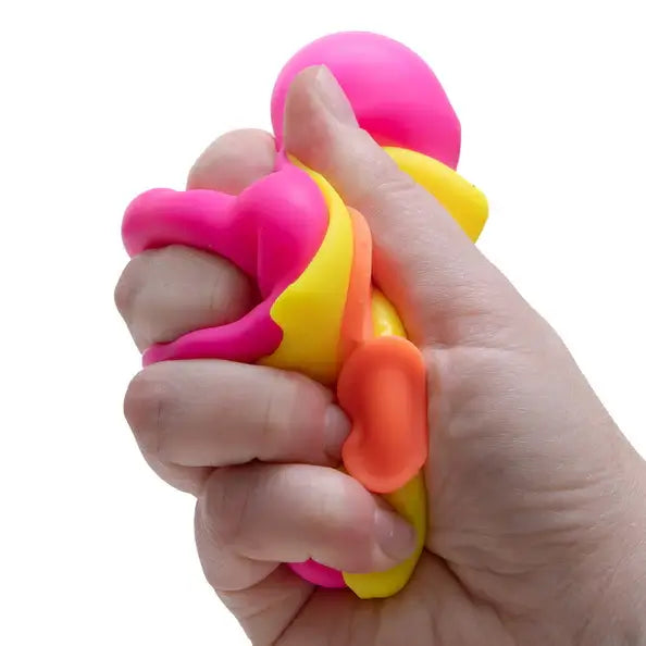 A hand squeezes the NeeDoh Squeezza.