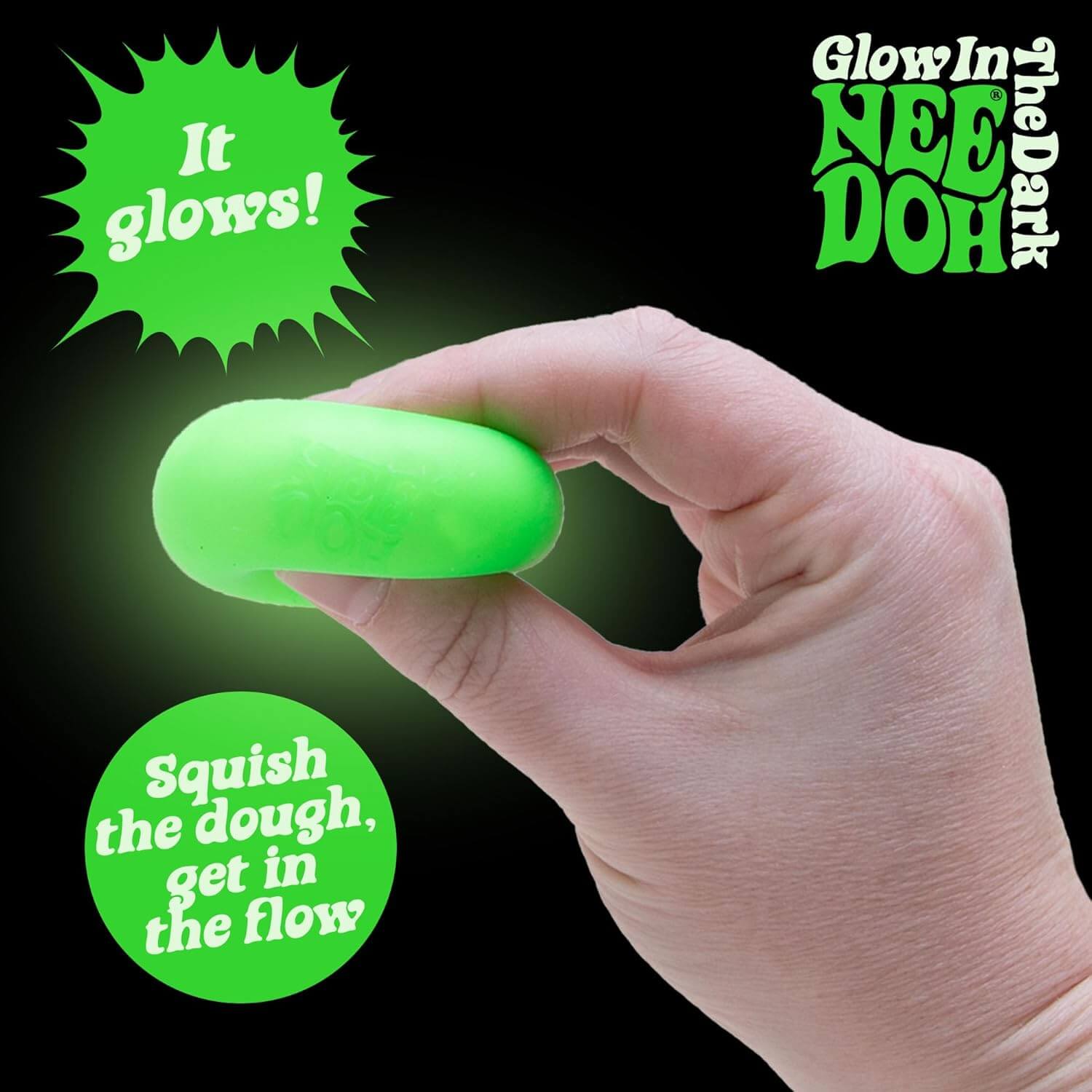 A hand squishes the glow-in-the-dark Teenie Fab Four NeeDoh.