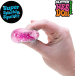 A hand squishes the sparkle Teenie Quad Squad NeeDoh.