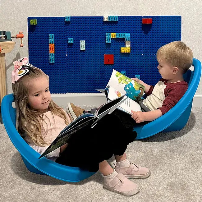 Two children sitting in blue Scoop Floor Rockers.