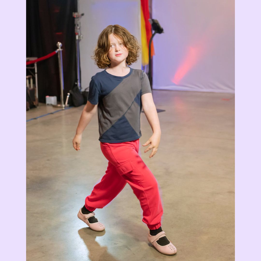 A child wears the coral Youth Sensory Friendly Fidget Jogger.