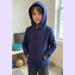 A child wears the hood up on their Sense-ational You Kids Marble Maze Fidget Hoodie.
