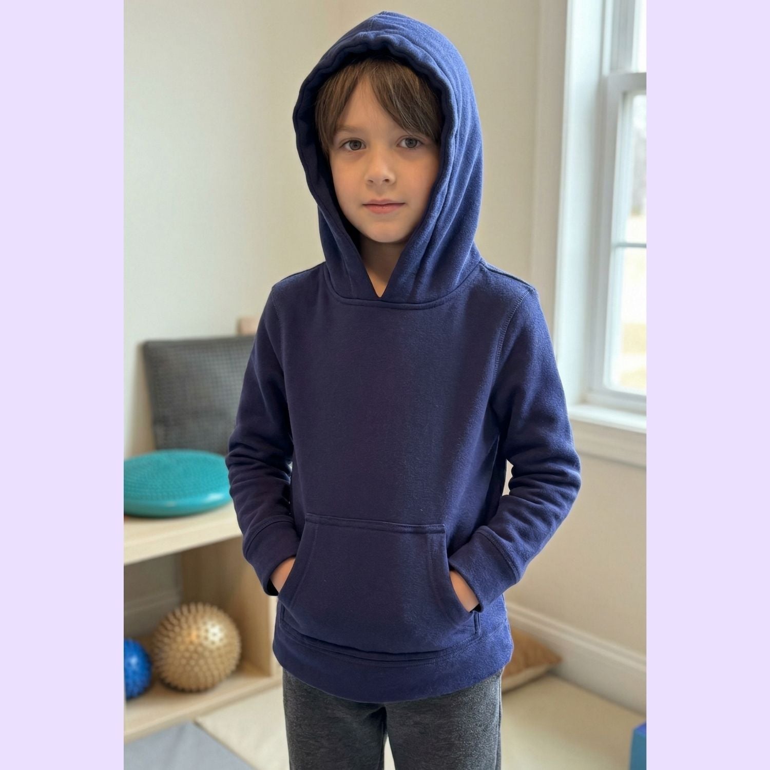 A child wears the hood up on their Sense-ational You Kids Marble Maze Fidget Hoodie.