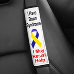 A seatbelt cover that says "I Have Down Syndrome, I May Resist Help."