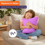 A child hugs the Purple and Grey Dual Sided Vibrating Pillow while sitting on a couch.