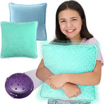 A child holds the Vibrating Pillow up to their chest while smiling.