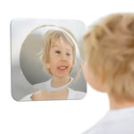 A child looks at their distored face in hte Sensory Bubble Wall Mirror.