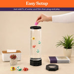 A hand drops the fish into the Table Top LED Aquarium Bubble Tube.