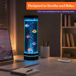 The Table Top LED Aquarium Bubble Tube glows on a desk next to an open laptop.