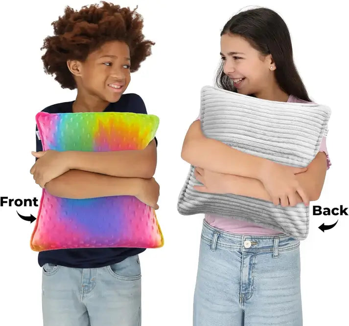 Two children hold different sides of the Dual Sided Vibrating Pillow - Rainbow & Grey.