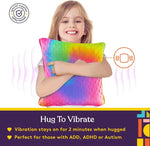 A child squeezes the Dual Sided Vibrating Pillow - Rainboy & Grey.